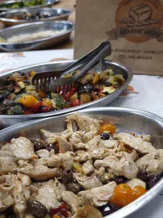 Vassoi di verdure grigliate e di pollo con le olive, pronti per un buffet