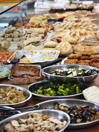 Il banco della gastronomia: pizzette, parmigiana, verdure e polpette