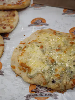 Pizzetta ai formaggi sulla carta con il logo del forno