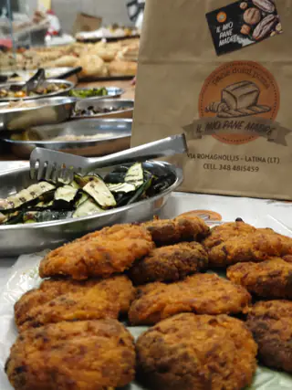 Polpette fritte e zucchine grigliate accanto al sacchetto del forno
