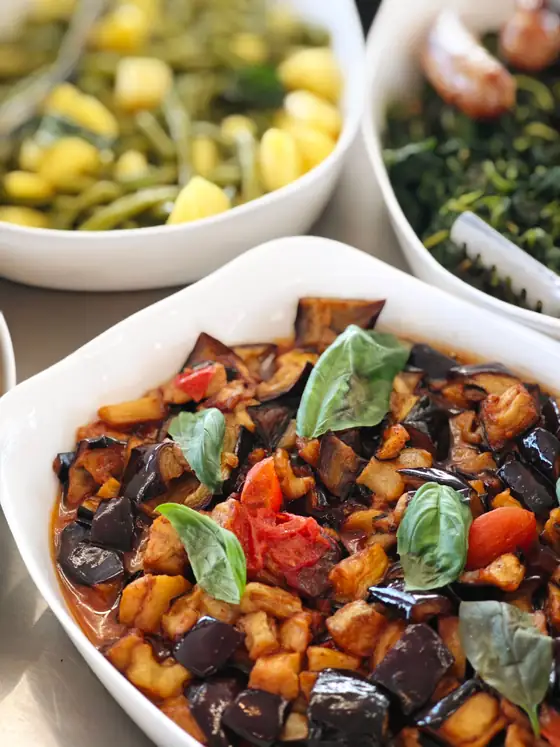 Melanzane con pomodorini e basilico, accanto a fagiolini e patate