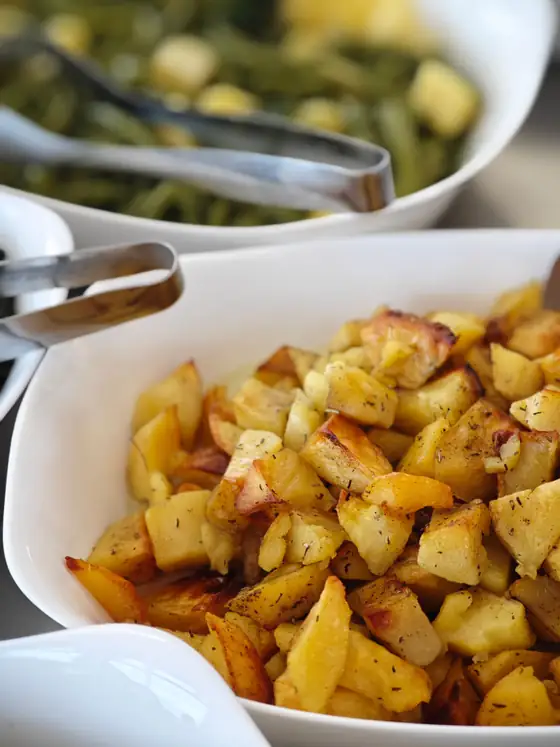 Patate al forno e fagiolini nei vassoi della tavola calda