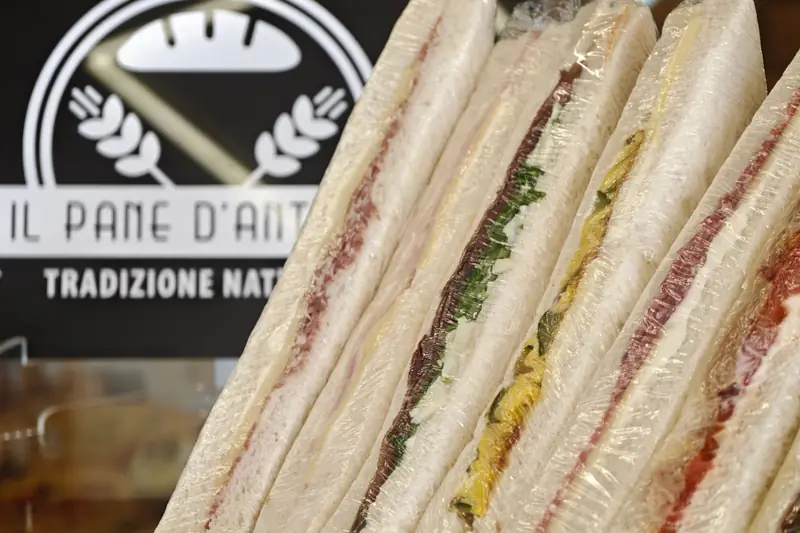 Tramezzini farciti in fila davanti all'insegna del Pane d'Antonio