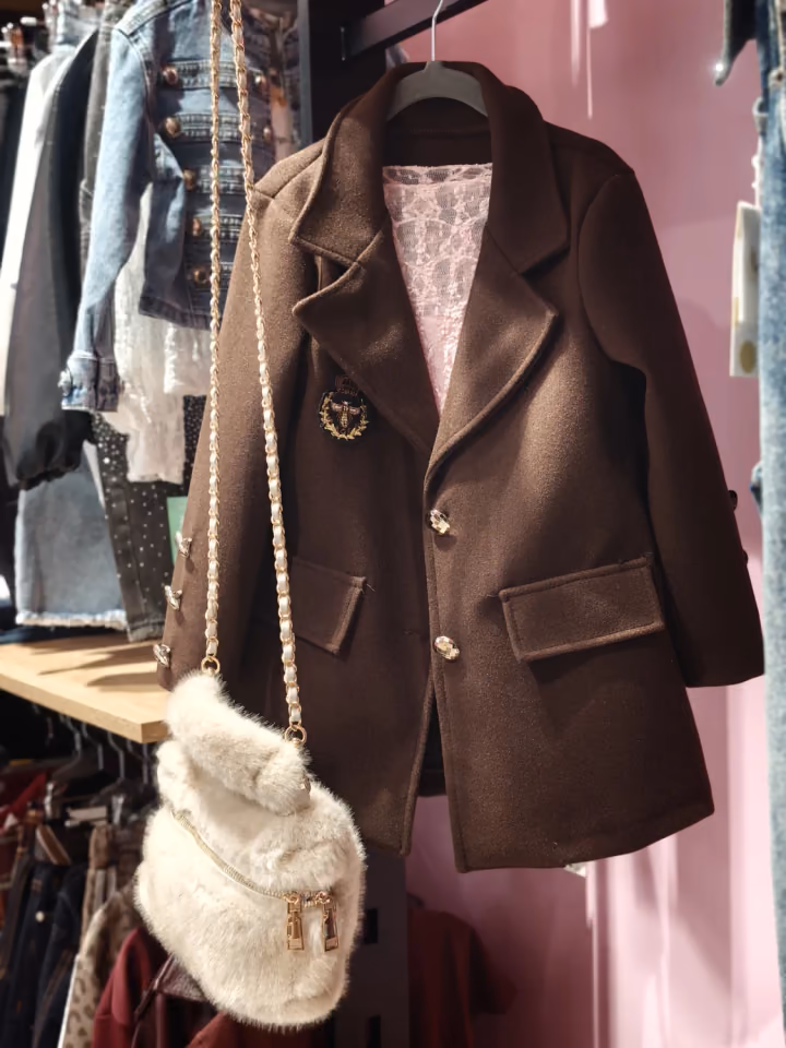 Cappotto marrone e borsa esposti in boutique