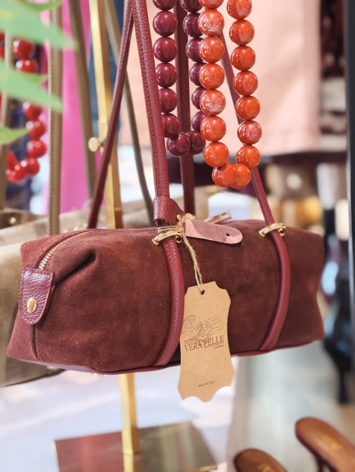 Borsa bordeaux e accessori in esposizione