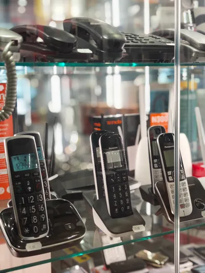 Telefoni cordless di varie marche su un ripiano di cristallo