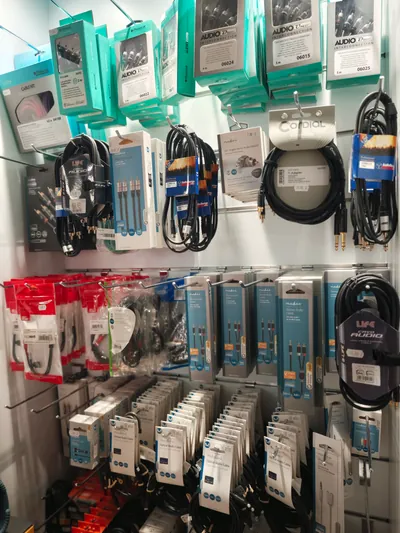 Cavi, adattatori e accessori audio nelle loro confezioni, sulla parete espositiva