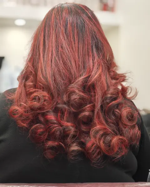 Capelli lunghi a boccoli, di un rosso ramato, visti di spalle