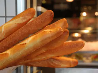 Filoni di pane dorati, davanti al banco del forno