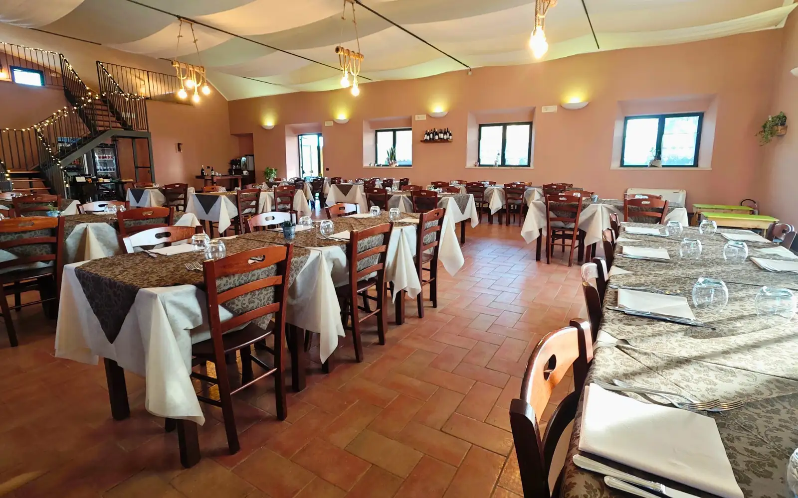 La sala da pranzo di Lindarella, con i tavoli apparecchiati e il soffitto a teli bianchi