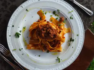 Pappardelle al ragù in un piatto bianco
