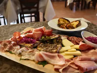 Un grande tagliere di salumi e formaggi sulla tavola della sala
