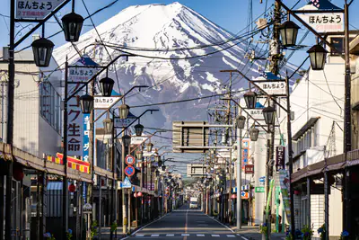 Una via di Fujiyoshida con i lampioni, e il Monte Fuji innevato in fondo
