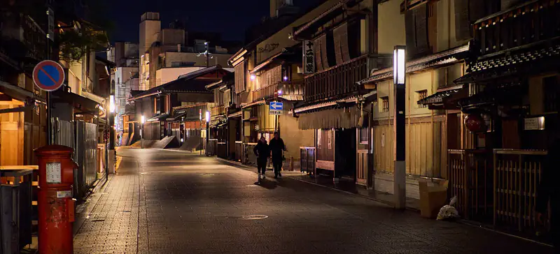 Una via di Kyoto la sera, tra le case di legno di Gion e le lanterne accese