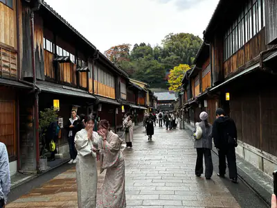 La via lastricata di Higashi Chaya, tra case da tè di legno, con due ragazze in kimono