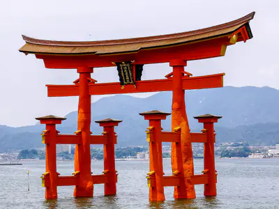 Il torii galleggiante di Itsukushima da vicino, con le colline dietro