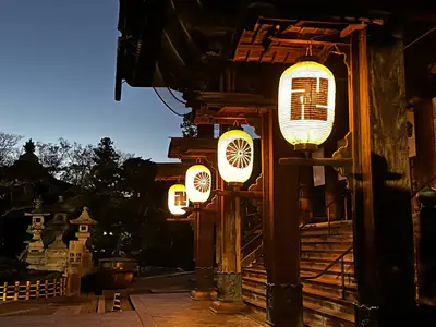 Le lanterne accese sotto la gronda di legno dello Zenko-ji, la sera