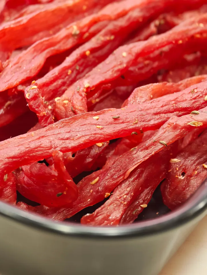Striscioline di carne essiccata con semi di finocchio in una ciotola grigia