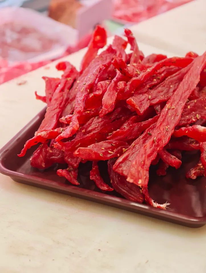 Striscioline di carne essiccata su vassoio rosso scuro