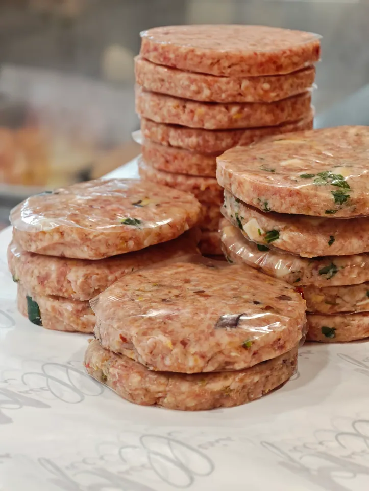 Pile di hamburger conditi con erbe e cubetti di formaggio