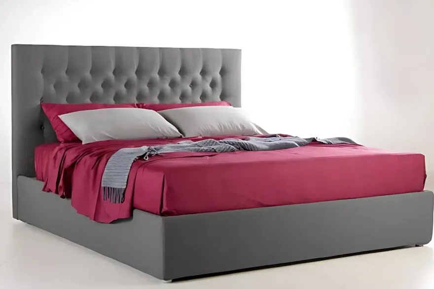 Letto Olimar con la testiera capitonné grigia, le lenzuola fucsia e i cuscini grigi, su fondo bianco