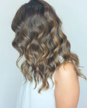 Onde castane con un balayage leggero, di tre quarti