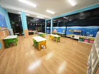 L'aula Dori con i tavoli, le sedie colorate e gli scaffali dei giochi