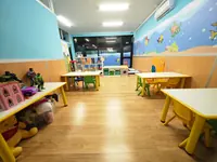 L'aula Varenne con i tavoli bassi e i giochi, sotto il mare dipinto