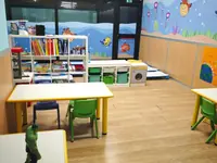 L'aula Varenne con il tavolo, le sedie verdi e la libreria colorata