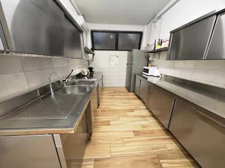 La cucina interna in acciaio, con i piani di lavoro e i lavelli