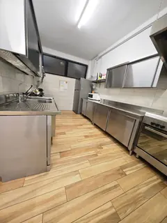 Un altro scorcio della cucina, con le cappe, i frigoriferi e il pavimento di legno