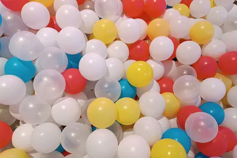 Una piscina di palline colorate, bianche, gialle, rosse e azzurre
