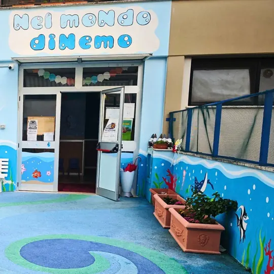 L'ingresso della scuola, con l'insegna «Nel moNdo diNemo» e il muro dipinto di pesci e onde