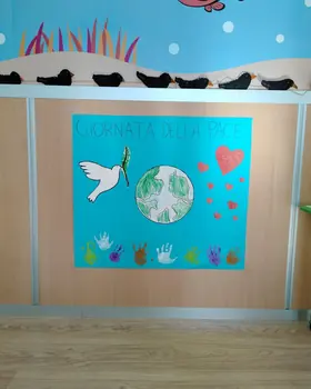 Il cartellone della Giornata della pace, con la colomba, il mondo e le impronte colorate delle mani