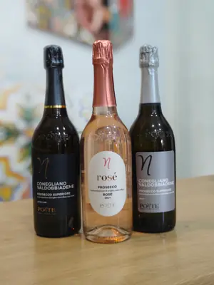 Tre bottiglie di prosecco sul bancone: due Conegliano Valdobbiadene e una rosé