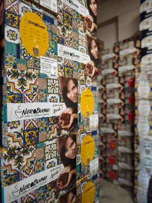Una parete del negozio rivestita di confezioni Nero Buono con le maioliche
