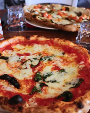 Una margherita appena sfornata, con il cornicione bruciacchiato dal forno a legna