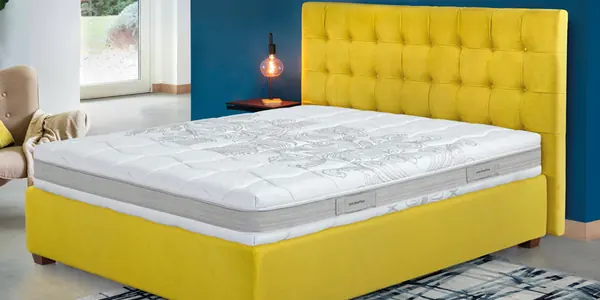 Letto con testiera capitonné gialla e materasso Permaflex