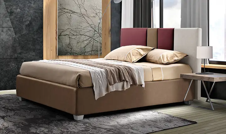Letto matrimoniale con testiera a pannelli bordeaux, beige e bianchi, in una camera moderna