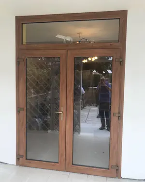 Portafinestra a due ante effetto legno con sopraluce e vetri decorati a losanghe