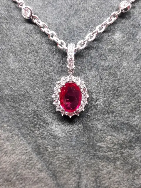Pendente con rubino ovale e contorno di diamanti su una catena in oro bianco