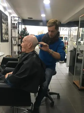 Il parrucchiere taglia i capelli a un cliente