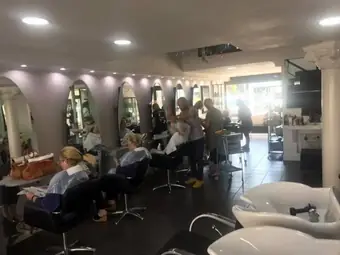 Le clienti sedute alle postazioni, sotto le luci del salone