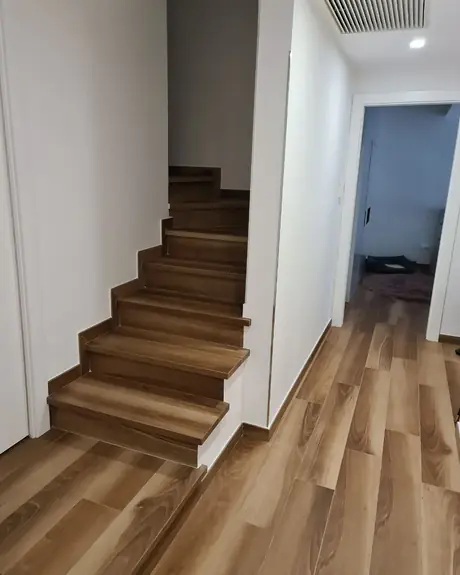 Scala e corridoio rivestiti in piastrelle effetto legno, a lavoro finito
