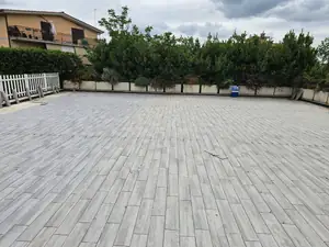 Grande cortile pavimentato con listoni effetto legno grigio