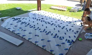 Posa di lastre all’aperto, fermate dai livellanti blu