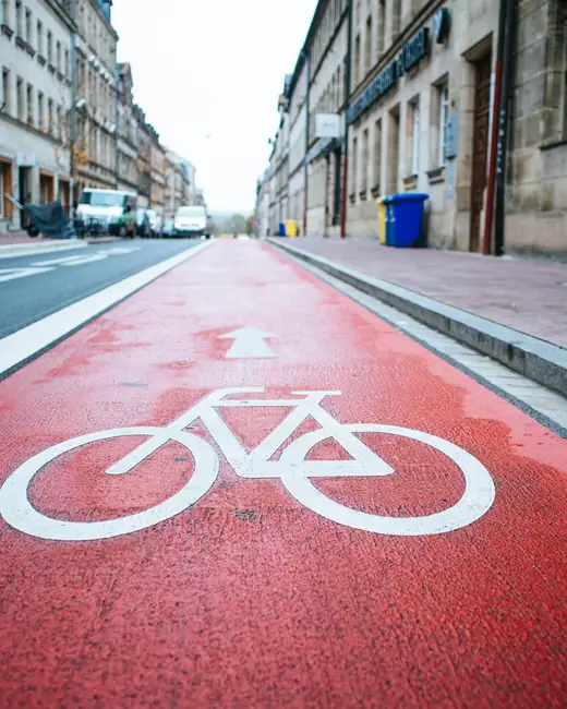 Pista ciclabile rossa con il simbolo della bicicletta dipinto in bianco
