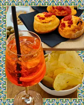 Uno spritz con pizzette, patatine e olive