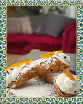 Due cannoli con ricotta, gocce di cioccolato e scorza d’arancia candita