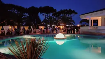 Una festa di sera attorno alla piscina illuminata